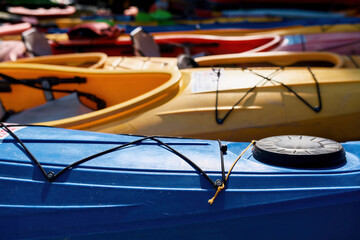 Set of colorful kayaks in row at sunny daytime