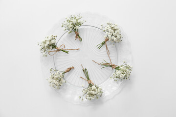 Plate with beautiful gypsophila boutonnieres on white background
