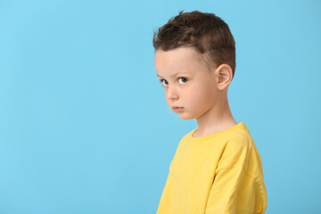 Portrait of cute little boy on color background