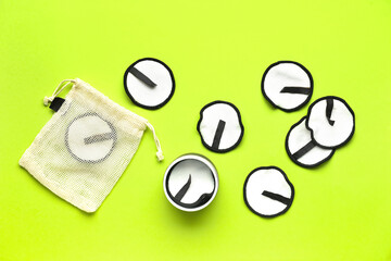 Reusable cotton pads and bag on color background