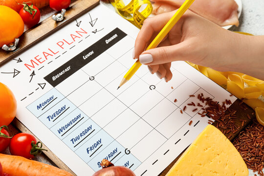 Woman Making Meal Plan On Table, Closeup