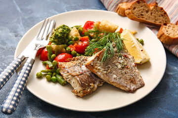 Plate with tasty baked cod fillet and vegetables on color background, closeup