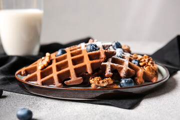 Plate of delicious Chocolate Belgian Waffles with blueberry and walnut on table