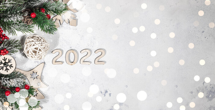 Happy New year 2022 banner, New Year light background decorated with fir branches, red Christmas balls and lights, bokeh lights background with free space for text