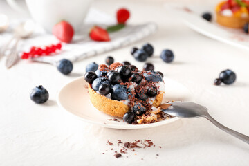 Plate with tasty berry tart on light background