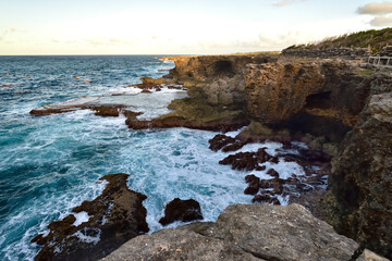 Rough ocean waves crashing against the rocky cliffs of North Point, Barbados, Caribbean