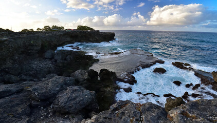 Rough ocean waves crashing against the rocky cliffs of North Point, Barbados, Caribbean