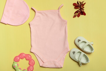 Mockup for design and placement of logos, advertising. Pink baby bodysuit, top view, mock up on yellow background.