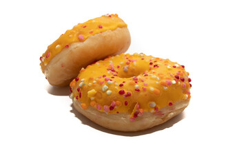 Orange donut decorated with colorful sprinkles isolated on white background. Mango flavor, very tasty and original. Novelty concept.