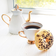 White vintage teapot and cup of coffee on white wooden background. Sweet breakfast
