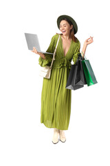 Happy young woman with laptop and shopping bags on white background. Black Friday sale