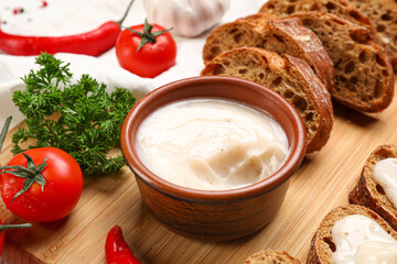 Bowl of lard spread, vegetables and bread on table