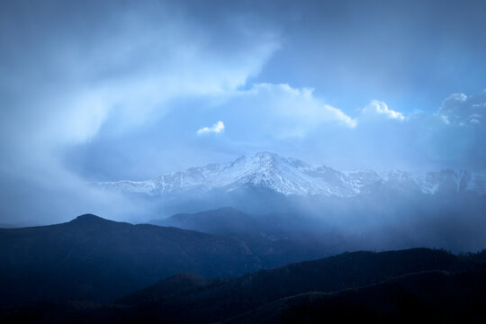 Pikes Peak Colorado snow capped mountain range with storm clouds