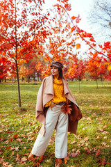 Full body portrait of beautiful woman wearing stylish clothes in autumn park. Female fall fashion