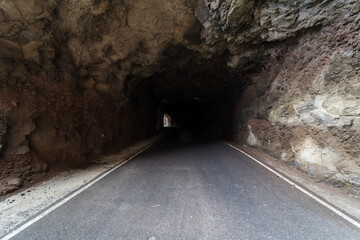 Car tunnel in the rock. The road to Cape Teno. Tenerife. Canary Islands. Spain.