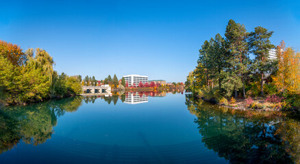 Panoramic view of the Upper Falls Reservoir and Dam at Riverfront Park in downtown Spokane, Washington, USA with leaves turning fall colors at autumn.