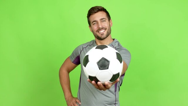 Handsome man holding a soccer ball over isolated background