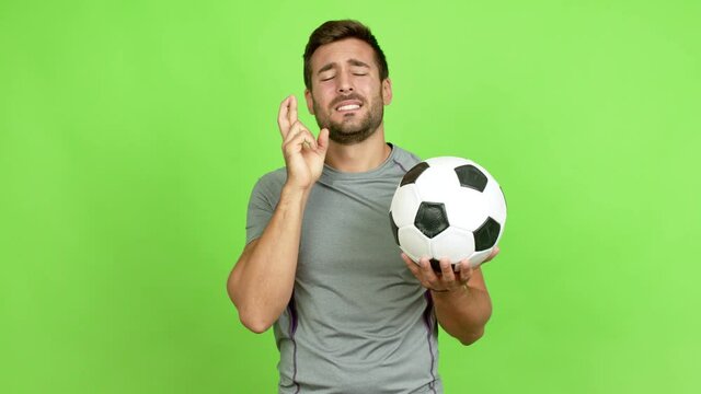 Handsome man playing futbol with fingers crossing over isolated background