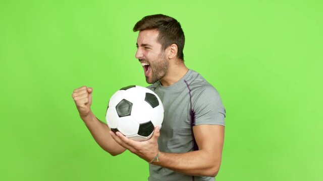Handsome man playing futbol and celebrating a victory over isolated background