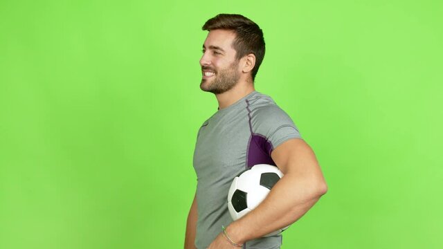 Handsome man playing futbol in lateral position over isolated background