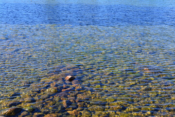 Water background texture with sand, and stones on sea bottom