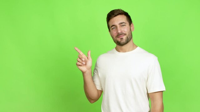 Handsome man pointing finger to the side and presenting a product over isolated background