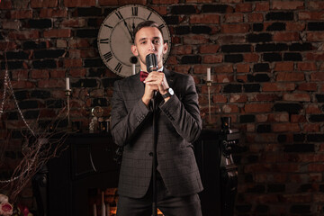 man in suit posing with condenser microphone. Emotional young man with a microphone in his hands