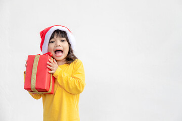Happy adorable Asian child girl with Christmas gift in hands on white background