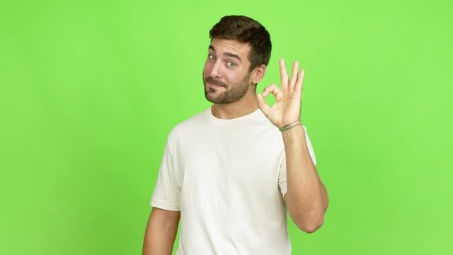 Handsome man showing ok sign with fingers over isolated background