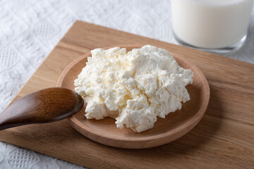 Bowl with fresh cottage cheese on table. Space for text