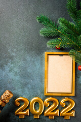Christmas photo frame mock up template with decoration on dark background. View from above. New year mockup. New year composition with champagne bottle and decor. New year 2022