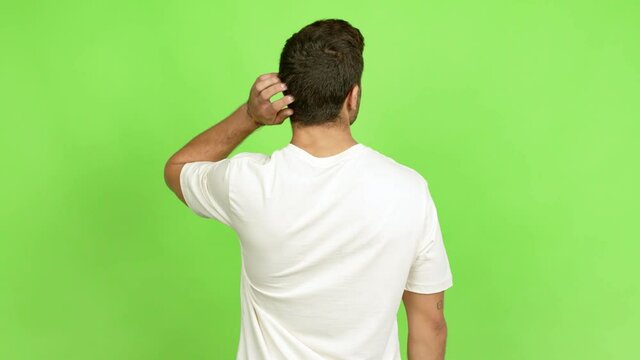 Handsome man on back position looking back while scratching head over isolated background
