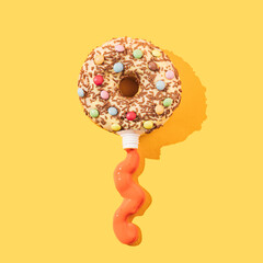 Creative composition made of donut and paint tube. Flat lay. Minimal concept.