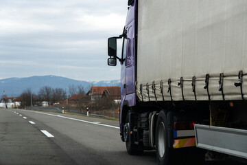 Fototapeta na wymiar Truck on the road and cloudy sky.