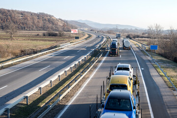 A large number of road vehicles. Cars and trucks in the highway.