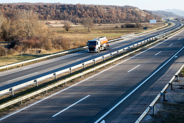 A big fuel tanker truck. truck movement to one side, road junction along the autobahn. 