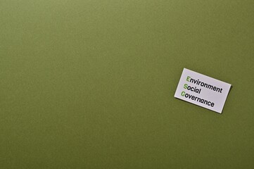 A card labeled "Environment, Social, Governance" is placed over a green background. With copy space.
