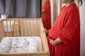 Fototapeta na wymiar asian pregnant women standing next to cribs