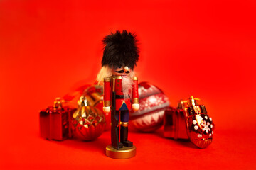 christmas nutcracker figurine with decorations on a red background