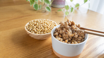 日本の納豆と生大豆。納豆を箸で混ぜる。	