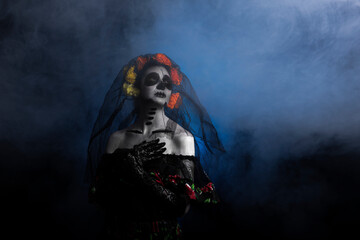 Young woman disguised for halloween as catrina on black background