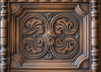 Old furniture piece from close, featuring carved pattern and a handle, background or backdrop copy-space