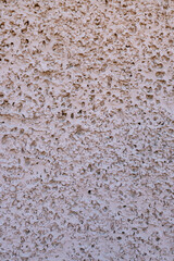 Rough stucco cement surface with a pink hue, large rough texture, background or copy-space