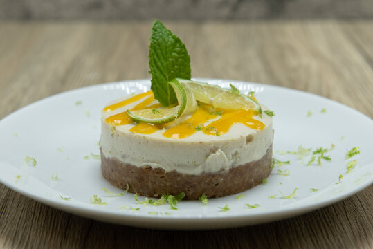 Overhead View Of Hearty Key Lime Pie Decorated With Icing, Lime Slice, And Mint Leaf