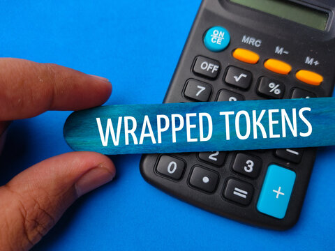 Hand holding colored ice cream stick and calculator written with text WRAPPED TOKENS.