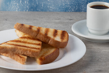 Hot toasted bread with butter served with coffee.