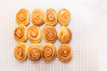 fresh baked buns lie on a white tablecloth. View from above. making homemade buns. home kitchen concept.
