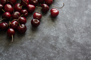 Dark background and ripe and juicy cherry, space for text
