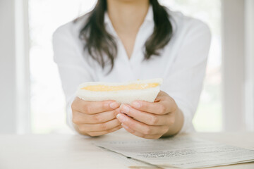 爽やかにサンドウィッチを頬張る女性