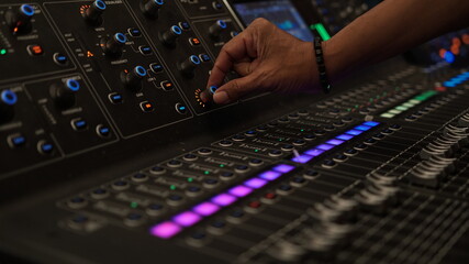 Male finger on audio mixer knob. Focus selected on the knob